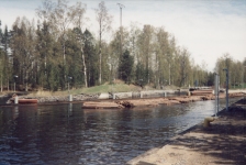 Vasemmalla puolella näkyy uittosulun pää (1917 - 1919). Tukkinippujen takana näkyy 1865 - 1867 rakennettu kanava.